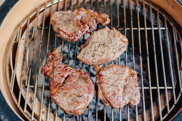 Marbled beef steak. The process of making steaks on the grill. Grilled steak. Rib eye steak. - Fotó, kép