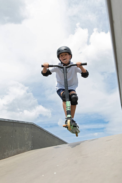 The boy jumps on a scooter - Fotoğraf, Görsel