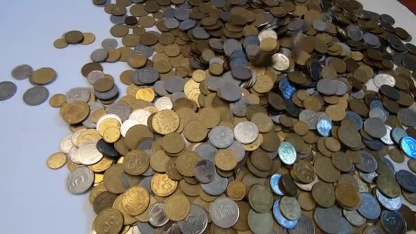 Person nimmt eine Handvoll Münzen in die Hand und wirft sie über Münzen auf den Tisch. - Filmmaterial, Video