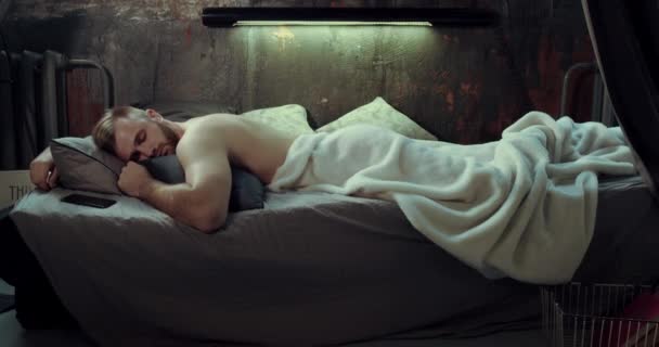 Un hombre barbudo y rubio medio desnudo durmiendo en su cama
. - Imágenes, Vídeo