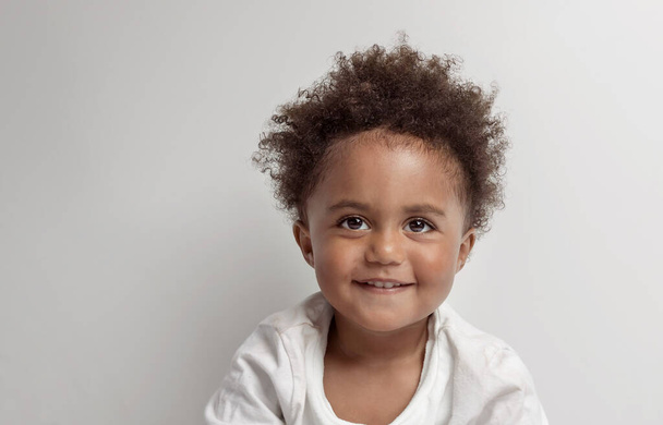 Portrait of a Nice Little African American Boy with Natuiral Afro Hair Style. isolated on Clear Grey Background. Happy Cute Child. - Zdjęcie, obraz