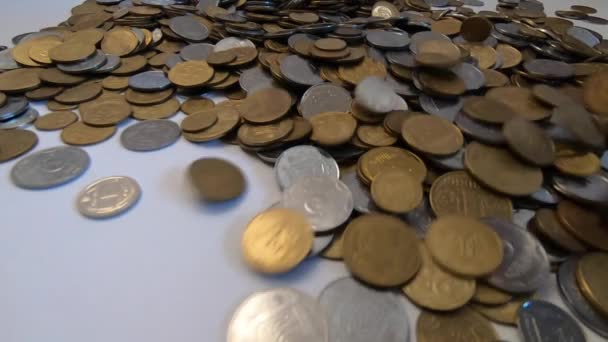 As moedas brancas e amarelas caem à superfície de close-up de moedas. - Filmagem, Vídeo
