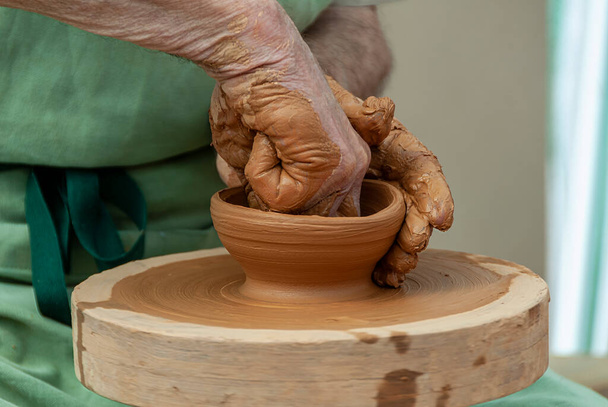 handen van pottenbakker het creëren van een pot op cirkel - Foto, afbeelding