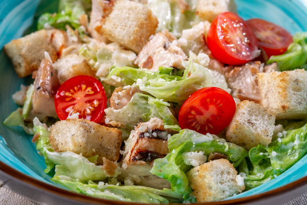 Caesar salát v misce se smaženým kuřetem, parmazánem, krutony a salátem, rustikální styl, zblízka - Fotografie, Obrázek