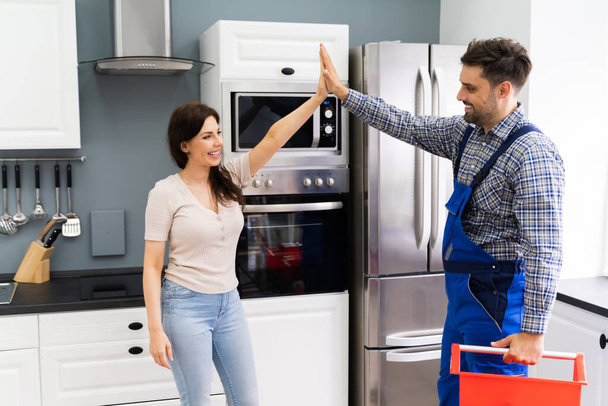 Happy Woman Doing High Five With Repairman After Fix - Photo, image