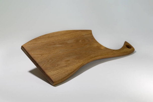 Beautiful carved wooden cutting Board on a white background, made by your own hands.For cooking and decorating the interior of the kitchen area - Φωτογραφία, εικόνα