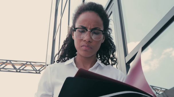 Αφρο-αμερικανίδα επιχειρηματίας που κοιτάζει εφημερίδες στον αστικό δρόμο - Πλάνα, βίντεο