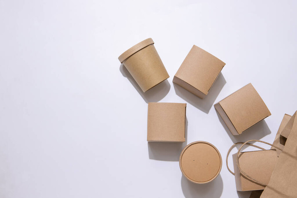 Cardboard containers and a bag for food, drinks and objects. White background. Isolate Top view. Copy space. Delivery concept, takeaway, craft packaging.   - Photo, Image