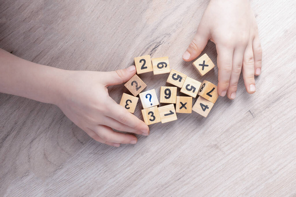 Wooden cubes with numbers. Teaching a child of preschool age mathematics. question mark. child learns numbers - Photo, Image