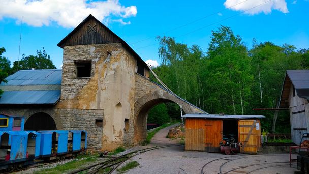 Antiguo edificio minero conservado en la mina checa no utilizada con ferrocarril durante el hermoso día de verano
. - Foto, imagen