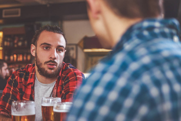 Πίνεις μπύρα και μιλάς στο μπαρ. - Φωτογραφία, εικόνα