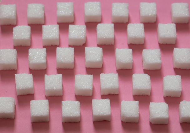Cubos de azúcar sobre fondo rosa
 - Foto, Imagen
