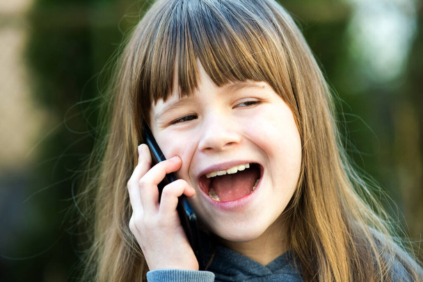 Portrait of pretty child girl with long hair talking on cell phone. Little female kid communicating using smartphone. Children communication concept. - Foto, Imagen