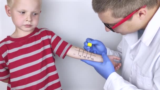 Ένας αλλεργιολόγος γιατρός κάνει δερματικό τεστ για αλλεργίες. Το αγόρι εξετάζεται στο εργαστήριο, περιμένοντας την αντίδραση σε αλλεργιογόνα.. - Πλάνα, βίντεο