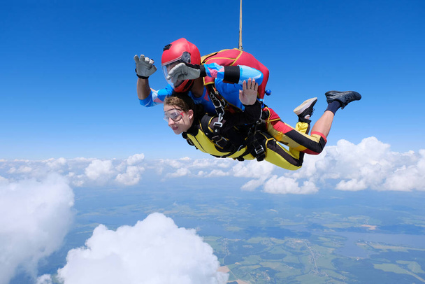 Skydiving. Tandem jump. A girl and her instrucror are flying in the sky. - Photo, Image