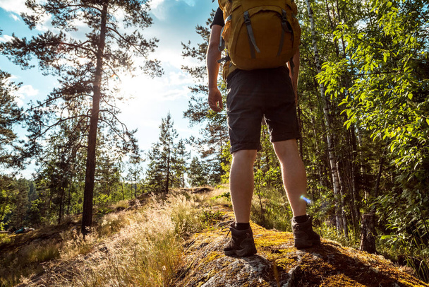 Man solo travel with a bright backpack hiking in nordic mountains active healthy lifestyle adventure. Travel and vacation concept - 写真・画像