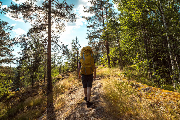 Man solo travel with a bright backpack hiking in nordic mountains active healthy lifestyle adventure. Travel and vacation concept - Foto, imagen