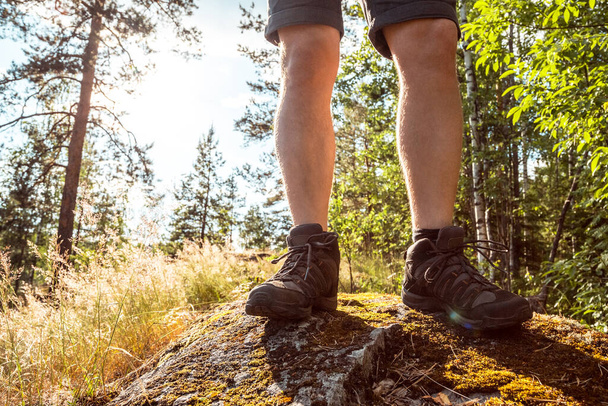 Legs in hiking shoes. Man solo travel hiking in nordic mountains active healthy lifestyle adventure. Travel and vacation concept - Fotó, kép
