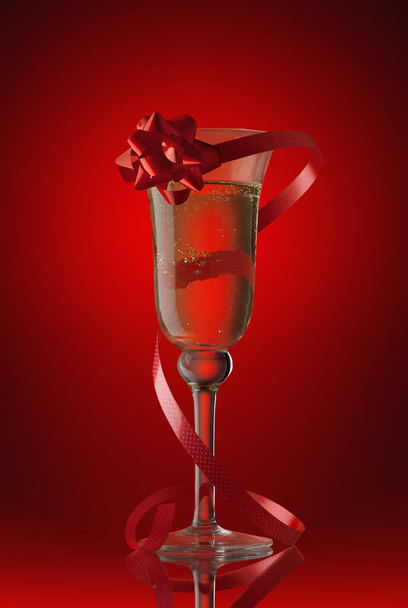 champagne glass with a red tape and a bow on  red background - 写真・画像