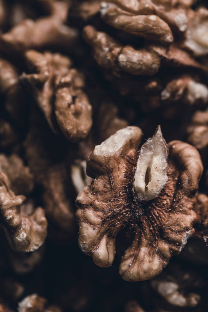 Walnut grain on a dark background close-up. Vertical orientation. - Foto, Bild