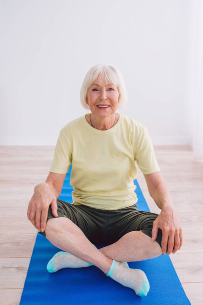 Seniorin macht Yoga drinnen. Anti-Alter, Sport, Yoga-Konzept - Foto, Bild