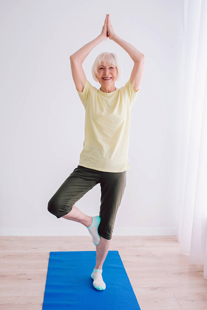 senior woman doing yoga indoor. Anti age, sport, yoga concept - 写真・画像