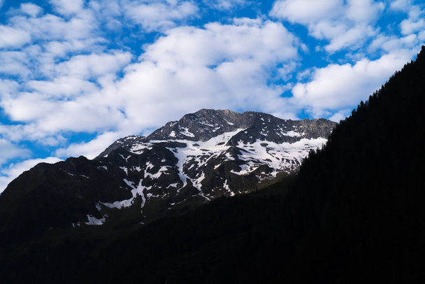 Szczyt górski z chmurami, krajobraz w Alpach Europejskich - Zdjęcie, obraz