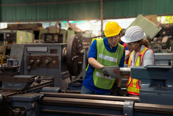 Ingénieurs d'usine et techniciens en chef surveillent le fonctionnement de la machine à travers les tablettes industrielles. - Photo, image
