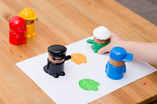 Lapsi oppii tuntemaan värejä. Pikkulapsi poika leikkii värejä hahmoja kupit oppimateriaaleja Montessori metodologiakoulussa manipuloidaan lapset. - Valokuva, kuva