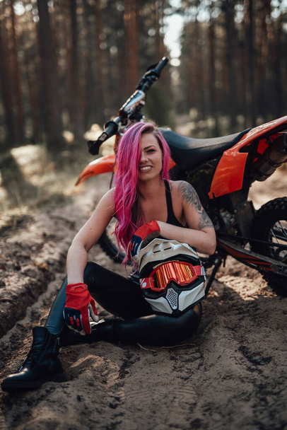 Portret van een charmante jonge vrouwelijke racer, lachend en kijkend naar de camera in off-road avontuur - Foto, afbeelding