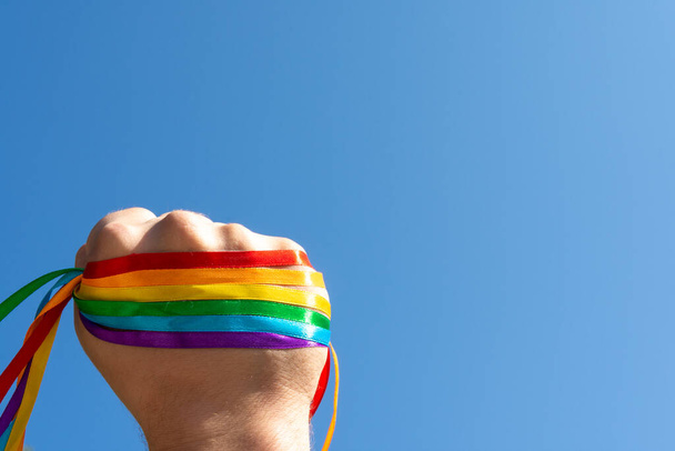 Gay pride concept. Hand making sign sign of unity and strength LGBT rainbow flag wristband - 写真・画像