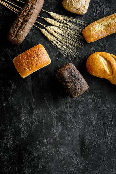 Set of loaves of bread on black desk from above copy space - Foto, immagini