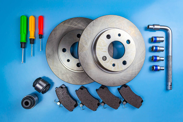 Auto parts, brake discs, pads. Salintblok car, starry auto keys, brake discs and pads, screwdrivers on a blue background - Photo, Image