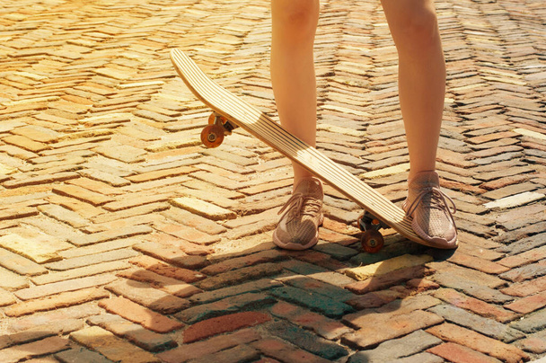 Жіночі ноги і ковзани крупним планом на свіжому повітрі в сонячний вечір або вдень. Яскрава старовинна фотографія
 - Фото, зображення
