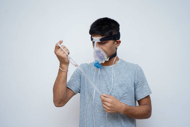 Joven guapo asiático adolescente usando una máscara de oxígeno, Stop Corona Virus y detener la contaminación concepto
. - Foto, Imagen