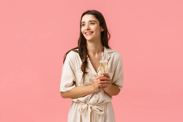 Elegance, romance and tenderness concept. Charming pretty brunette woman in lovely dress contemplating beautiful wedding ceremony, being guest party, holding glass champagne and smiling - Photo, Image