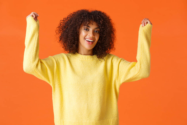 Relish, triumphing and champion concept. Excited happy african-american young girl with afro haircut, raising hands up from excitement and happiness, cheering winning, celebrate victory - Fotoğraf, Görsel