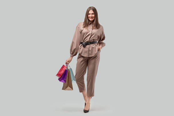 Full growth business woman holding shopping bags in her hands. - Photo, image