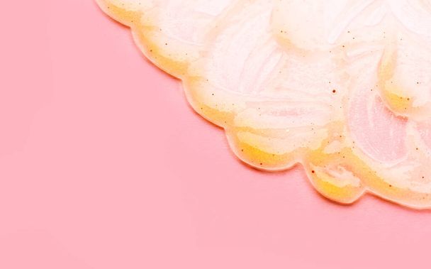 Transparente Gesichtsmaske mit Partikeln natürlicher Bestandteile. Gel-Gesichtsmaske auf rosa Hintergrund. - Foto, Bild