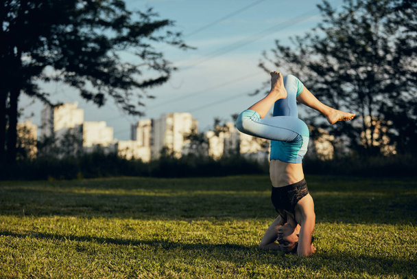 Женщина, стоящая на голове в поддерживаемой позе йоги на голове
. - Фото, изображение