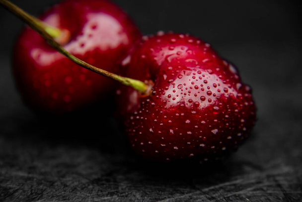 Close up of fresh, healthy and wet sweet cherry berry with water drops on it. - Foto, Bild