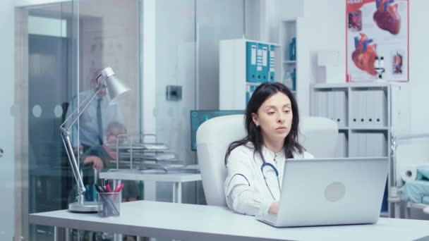 Nuori nainen lääkäri kirjoittaa kannettavaan tietokoneeseen - Materiaali, video