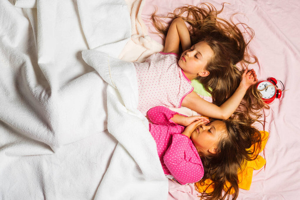 Kids in pink pajamas covered with white blanket - Foto, Bild