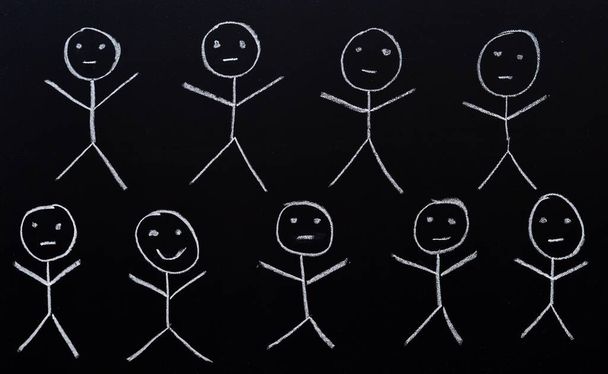 Group of human figures drawn in chalk on a blackboard - Photo, Image