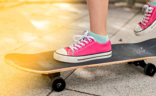 πόδια ενός κοριτσιού που χρησιμοποιεί ένα skateboard - Φωτογραφία, εικόνα