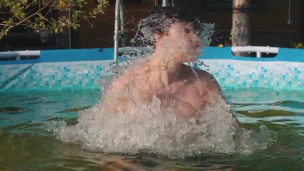 若い男が水から飛び降りて髪を水から振り出し - 映像、動画