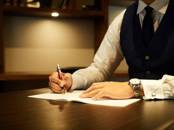 Ein männlicher Geschäftsmann unterschreibt ein Dokument. - Foto, Bild