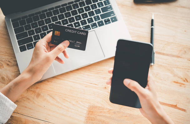 Damskie ręce trzymające kartę kredytową i pracujące na laptopie Płatność online za zakupy online - Zdjęcie, obraz