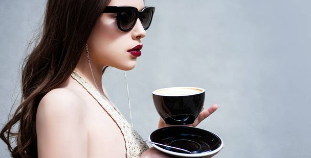 Coffee. Beautiful Girl Drinking Tea or Coffee. Beauty Woman enjoying Coffee. Cup of Hot Beverage. Morning. Beautiful fashion model posing in glasses. Beauty trends. - Φωτογραφία, εικόνα