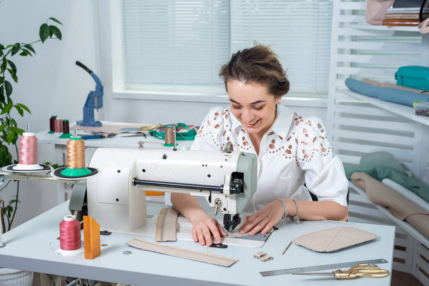 atelier empleado garabatos pequeñas partes de artículos de cuero en una máquina de coser
 - Foto, imagen